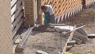 A térburkolás szegélykövek betonágyba helyezése.